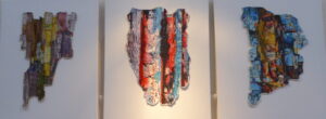 A triptych of layered embroidered appliqued art representing peeling paint.