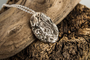 Silver pendant molded on a pebble
